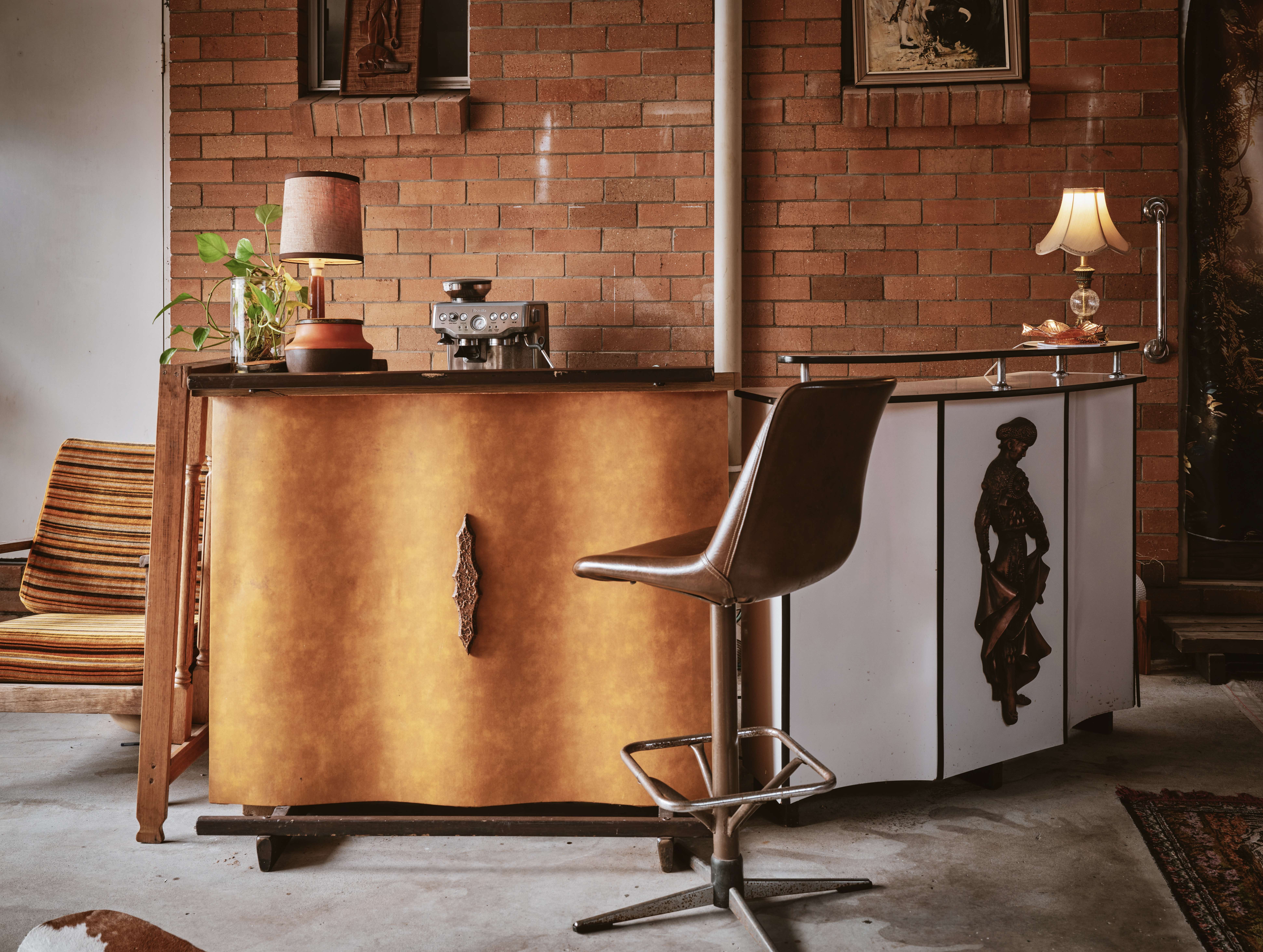 Cream leather armchairs beneath the ships-at-dusk painting