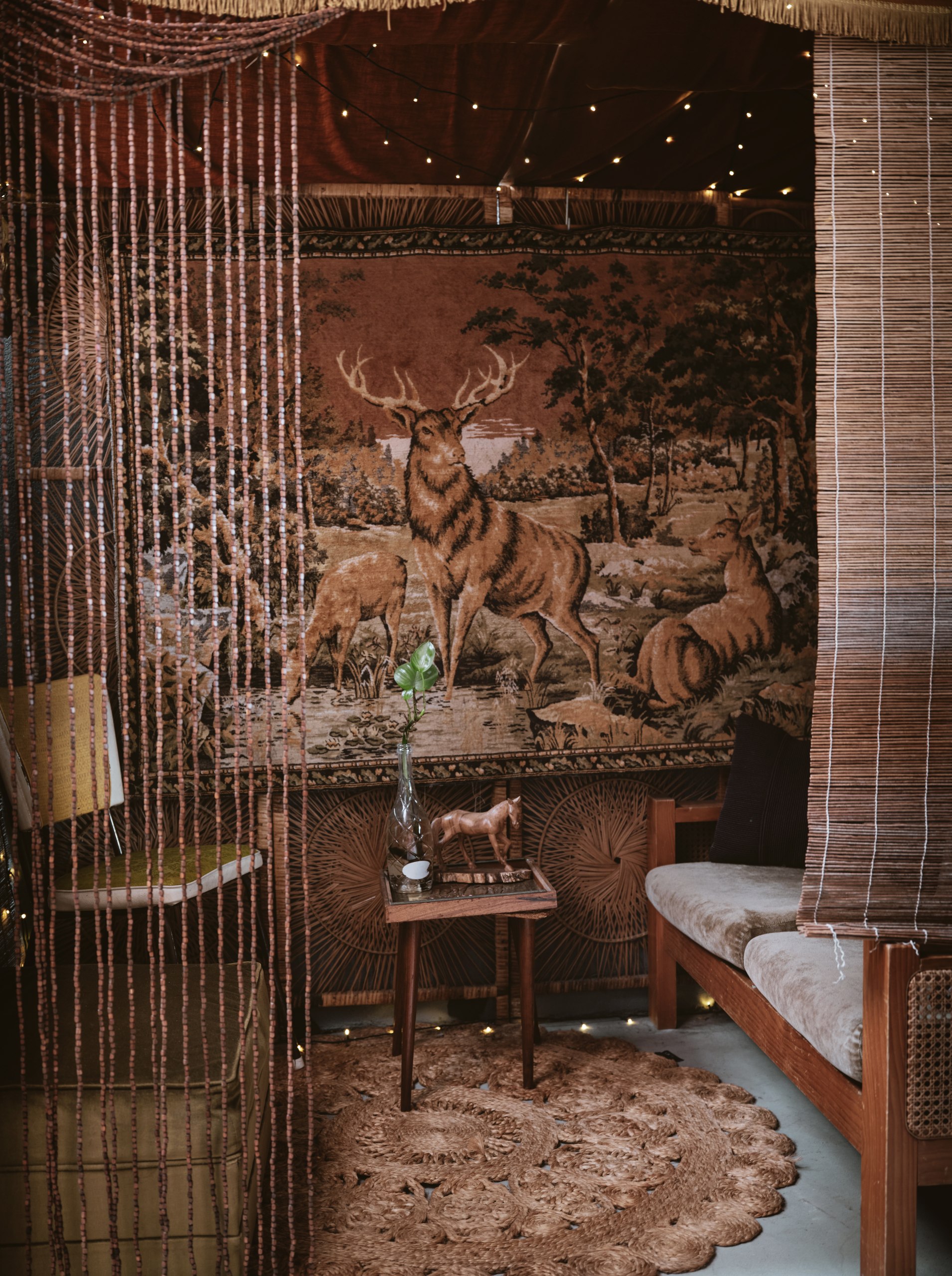 Beaded curtain and deer tapestry nook, a private breakout space within Joy's on the Avenue